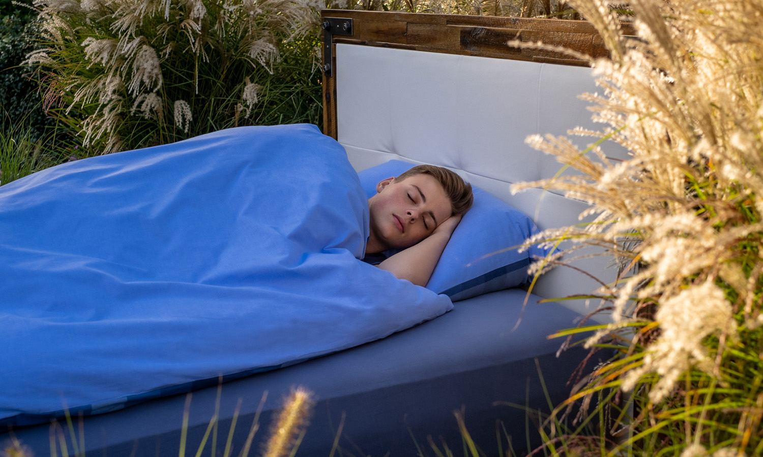 Junger Mann schläft im Bett in Natur