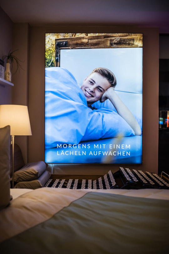 Junger Mann lächelt im Bett